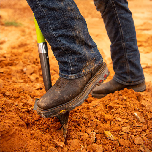 mens work boots on shovel